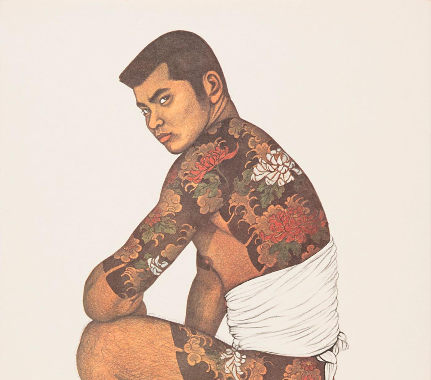 A Japanese man with short hair crouches down and looks over his shoulder; he has a flowered tattoo that extends across his back down to his biceps and thighs