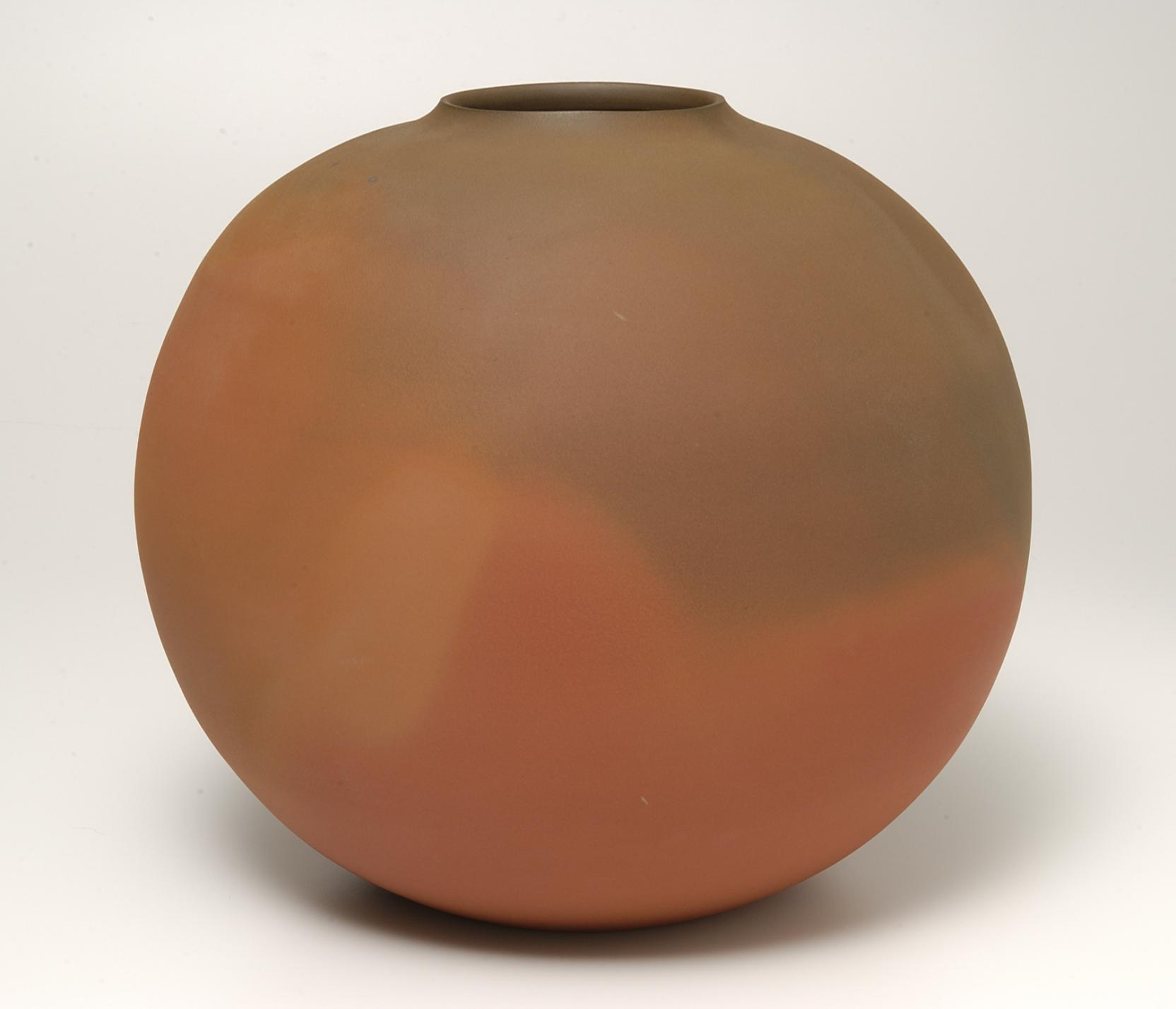 Round jar with a faintly raised neck and round opening, featuring color gradations of red, orange, brown, and grey