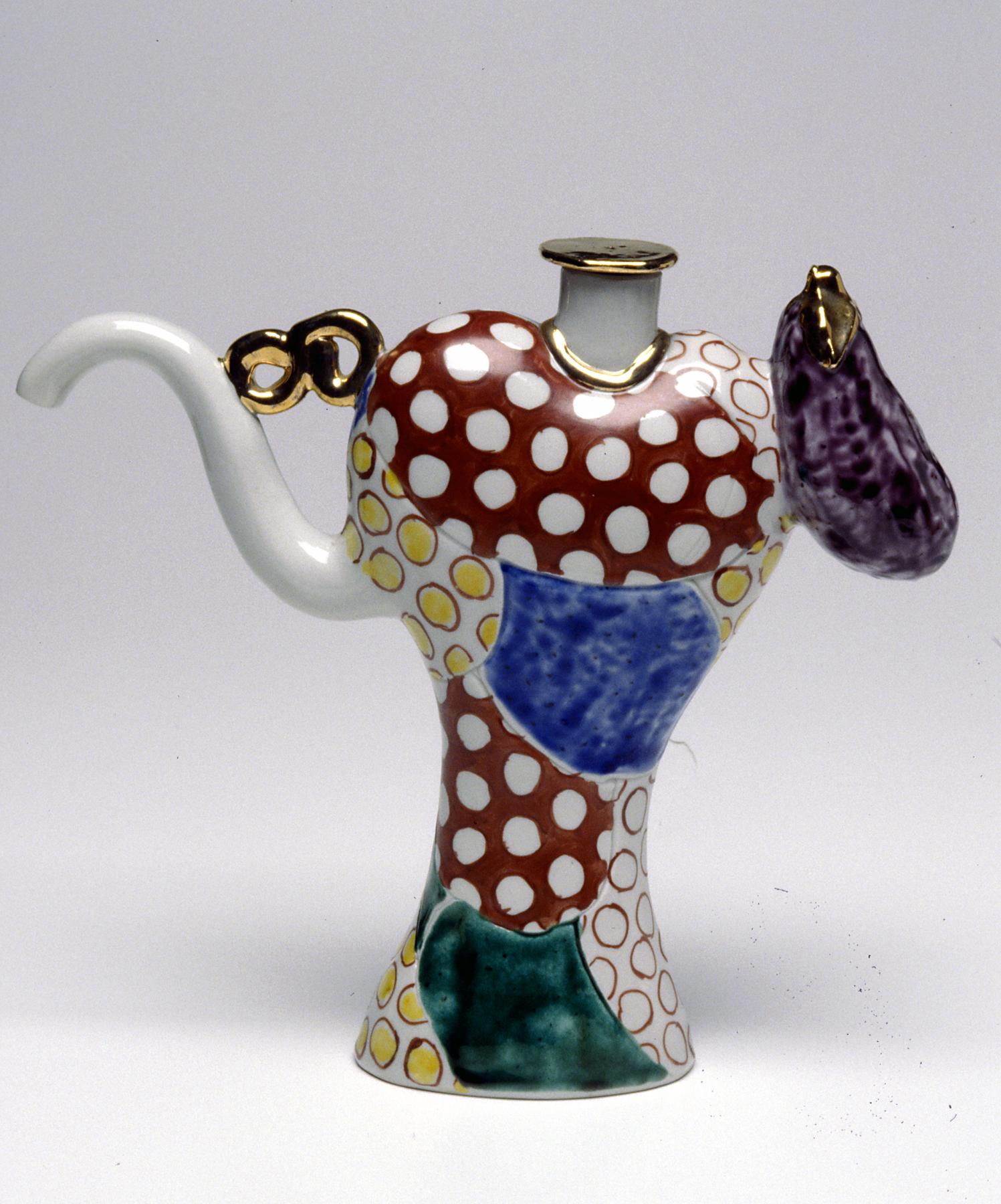 Tall, slender teapot with a long, curved spout and eggplant-shaped handle; body decorated with polka dots and patches of solid color