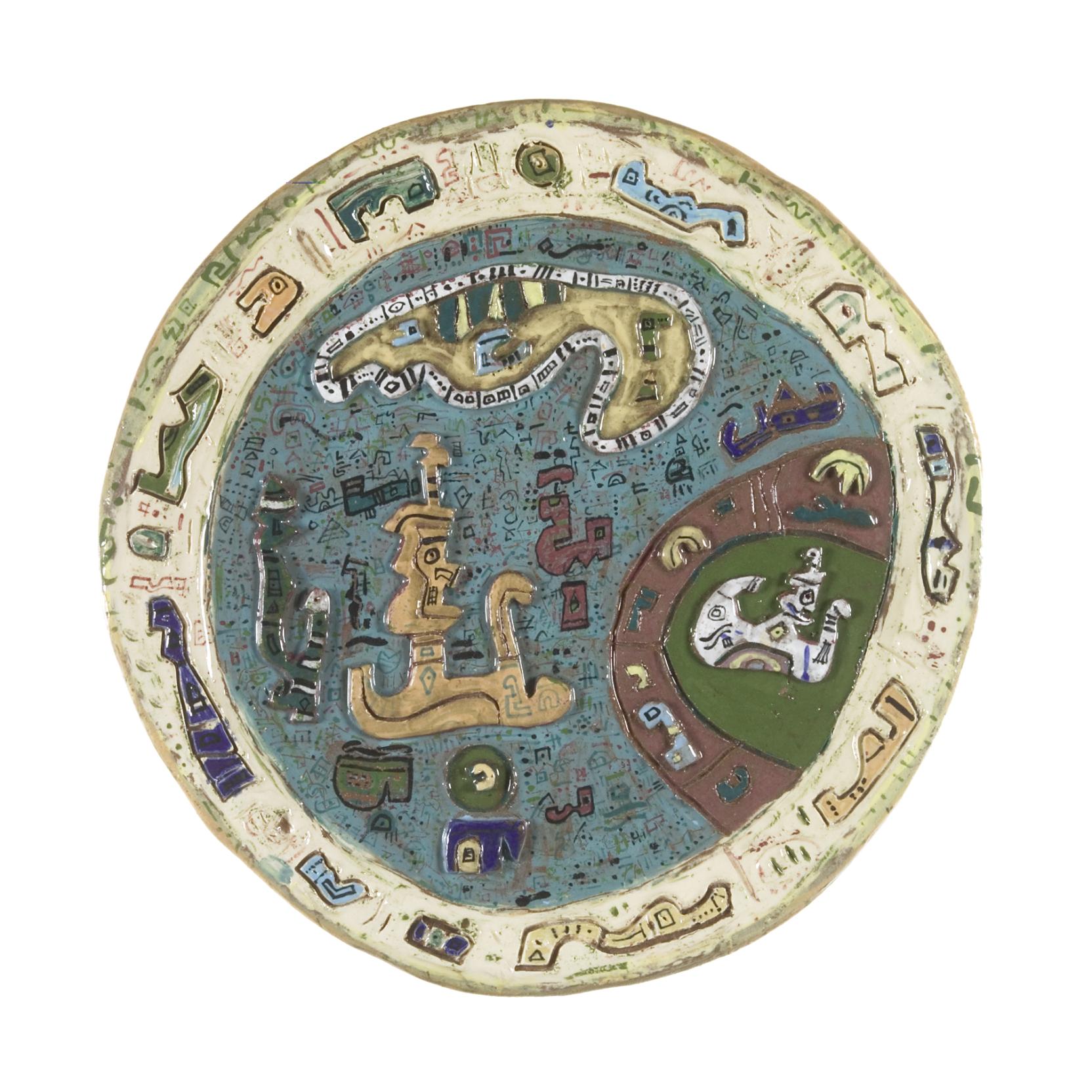 Circular plate featuring a blue well, beige border, and green rim, decorated with raised drawings of animal-like figures and geometric motifs